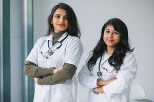 dos joven indio mujer médico mirando a cámara en el hospital foto