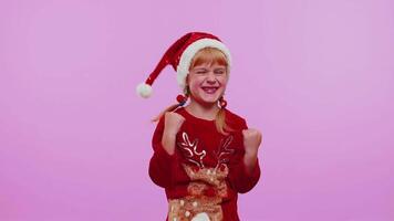 Cheerful girl kid in sweater Christmas Santa shouting, celebrating success, winning, goal achievemen video