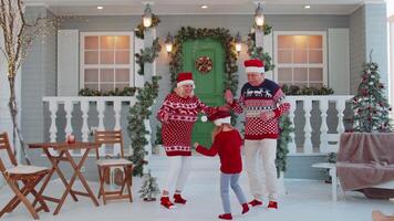 alegre antiguo abuelos con nieta niño niño bailando alrededor decorado Navidad casa árbol video