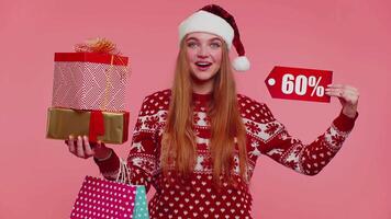 mulher dentro Natal suéter mostrando presente caixas e 60. por cento desconto inscrições bandeira texto Nota video