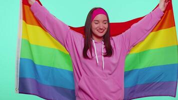 Cheerful cute girl smiling with rainbow LGBT flag celebrate parade show tolerance same sex marriages video