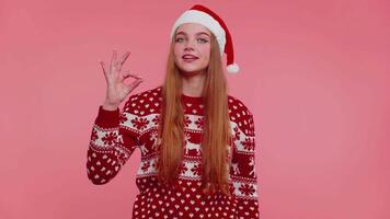 adulto ragazza nel Natale maglione guardare con approvazione a telecamera mostrando ok gesto, piace cartello positivo video