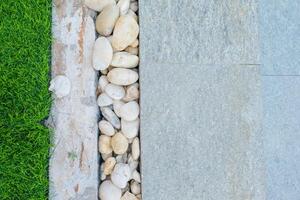 White and brown stone decorated in between walkway and lawn and tiles pattern. Landscape design detail. photo