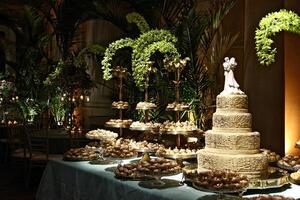 beautiful golden and decorated wedding cake on the sweets table at party photo