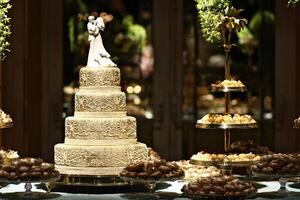 beautiful golden and decorated wedding cake on the sweets table at party photo