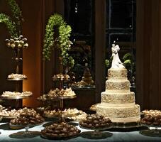 beautiful golden and decorated wedding cake on the sweets table at party photo