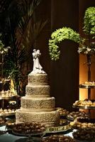 beautiful golden and decorated wedding cake on the sweets table at party photo