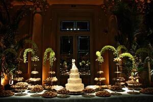 beautiful golden and decorated wedding cake on the sweets table at party photo