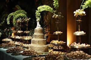 beautiful golden and decorated wedding cake on the sweets table at party photo