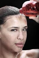 beautiful and smiling model playing with water bottles in studio photo