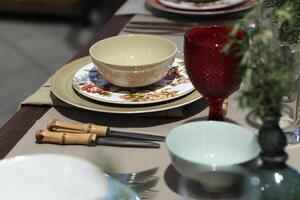 setting up sophisticated tables with various types of bowls, plates and glasses photo