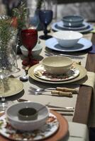 setting up sophisticated tables with various types of bowls, plates and glasses photo