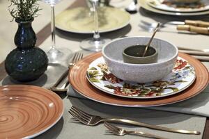 setting up sophisticated tables with various types of bowls, plates and glasses photo