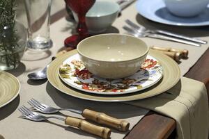 setting up sophisticated tables with various types of bowls, plates and glasses photo