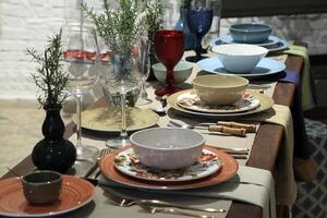 setting up sophisticated tables with various types of bowls, plates and glasses photo