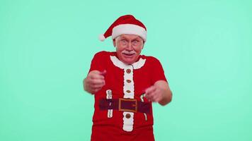 anziano Natale nonno uomo sorridente animatamente, puntamento per telecamera, bellezza la scelta fortunato vincitore video