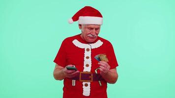 Christmas grandfather using credit bank card, smartphone while transferring money shopping online video