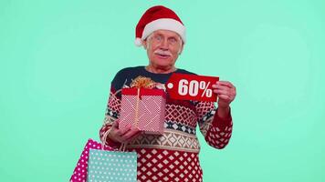 Grandfather in Christmas sweater showing gift box and 60 Percent discount inscriptions banner text video