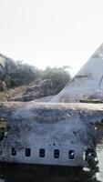 Plane wreck on the beach with rocks near ocean video