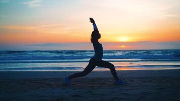 silueta mujer práctica yoga guerrero actitud a meditación con verano vacaciones playa felicidad y relajación. calma hembra ejercicio con yoga meditar Oceano playa con puesta de sol dorado tiempo. foto