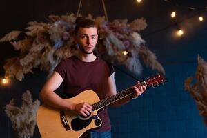 masculino músico jugando acústico guitarra. guitarrista obras de teatro clásico guitarra en etapa en concierto foto