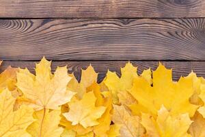 otoño hojas marco en de madera antecedentes parte superior ver otoño frontera amarillo y naranja hojas Clásico madera mesa Copiar espacio para texto. foto