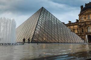 París, Francia. 01 junio 2018 lumbrera museo cuadrado con verano puesta de sol. el antiguo Renacimiento edificio es ilustrado por el Dom y el vaso pirámide es en pie en el medio. foto