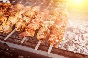 Grilled kebab cooking on metal skewer. Roasted meat cooked at barbecue. BBQ fresh beef meat chop slices. Traditional eastern dish, shish kebab. photo