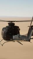 A helicopter flying over a desert with a rock formation in the background video