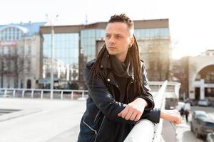 rocker rock star young man walking on the city street autumn day photo