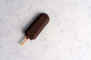 hielo crema palo en oscuro blanco antecedentes cubierto chocolate palos congelado paleta de hielo y paleta dulce postre plano laico foto