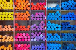 Multicolored pastel crayons art store in wooden cells photo