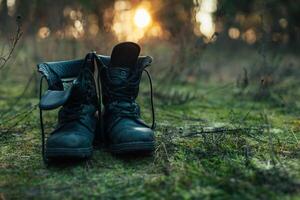 Close up of vintage pair of walking boots on boulder grassland background. photo