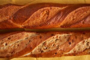 two crispy french baguettes lie on an old wooden table with free space for text photo