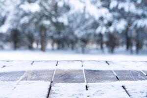 Beautiful winter scene. blurred background of snowy christmas nature background, Wood table top on shiny bokeh. For product display Christmas time mock up photo