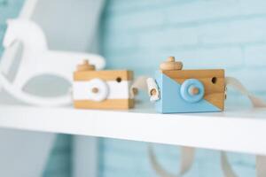Toy wooden camera for children or decoration standing on shelf photo