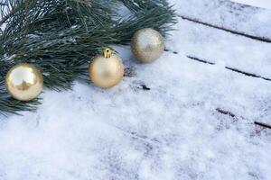 Winter background. Empty wooden plank with snowy border with pine branch and christmas ball decoration photo