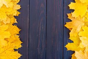 otoño hojas marco en de madera antecedentes parte superior ver otoño frontera amarillo y naranja hojas Clásico madera mesa Copiar espacio para texto. foto