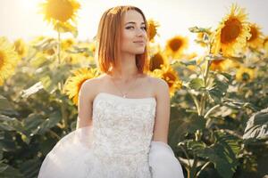 hermosa joven novia posando en un girasol campo foto