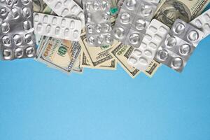 pills empty blisters for drugs individual syringe and money lie on a blue background photo