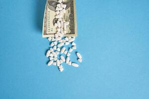 pills empty blisters for drugs individual syringe and money lie on a blue background photo