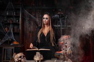 Halloween, witch use magic book and cauldron prepare poison or love potion photo