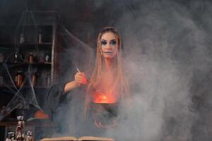 Halloween, witch use magic book and cauldron prepare poison or love potion photo