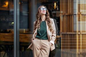 negocio mujer restaurante propietario vestido elegante traje pantalón en pie cerca restaurante grande ventana foto