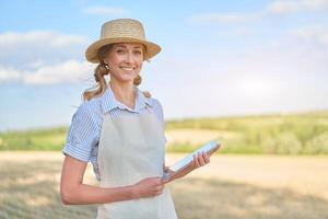 Woman farmer straw hat smart farming standing farmland smiling using digital tablet Female agronomist specialist research monitoring analysis data agribusiness photo