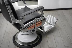 Classic vintage barber chair stands opposite mirror stylish white barber shop interior. photo