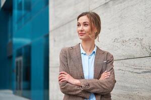 Blonde business woman put her hands together and look away. The hair is gathered in a bun. Business concept. photo