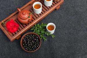 Traditional Chinese tea ceremony with black currant, fruit tea and healthy food. Photo without people. Summer natural vitamins and berries