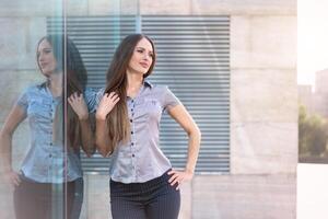 negocio mujer 35 años vestido raya camisa con largo pelo en pie cerca oficina edificio al aire libre foto