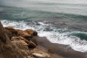 sea wave washes yellow beach of pebbles photo